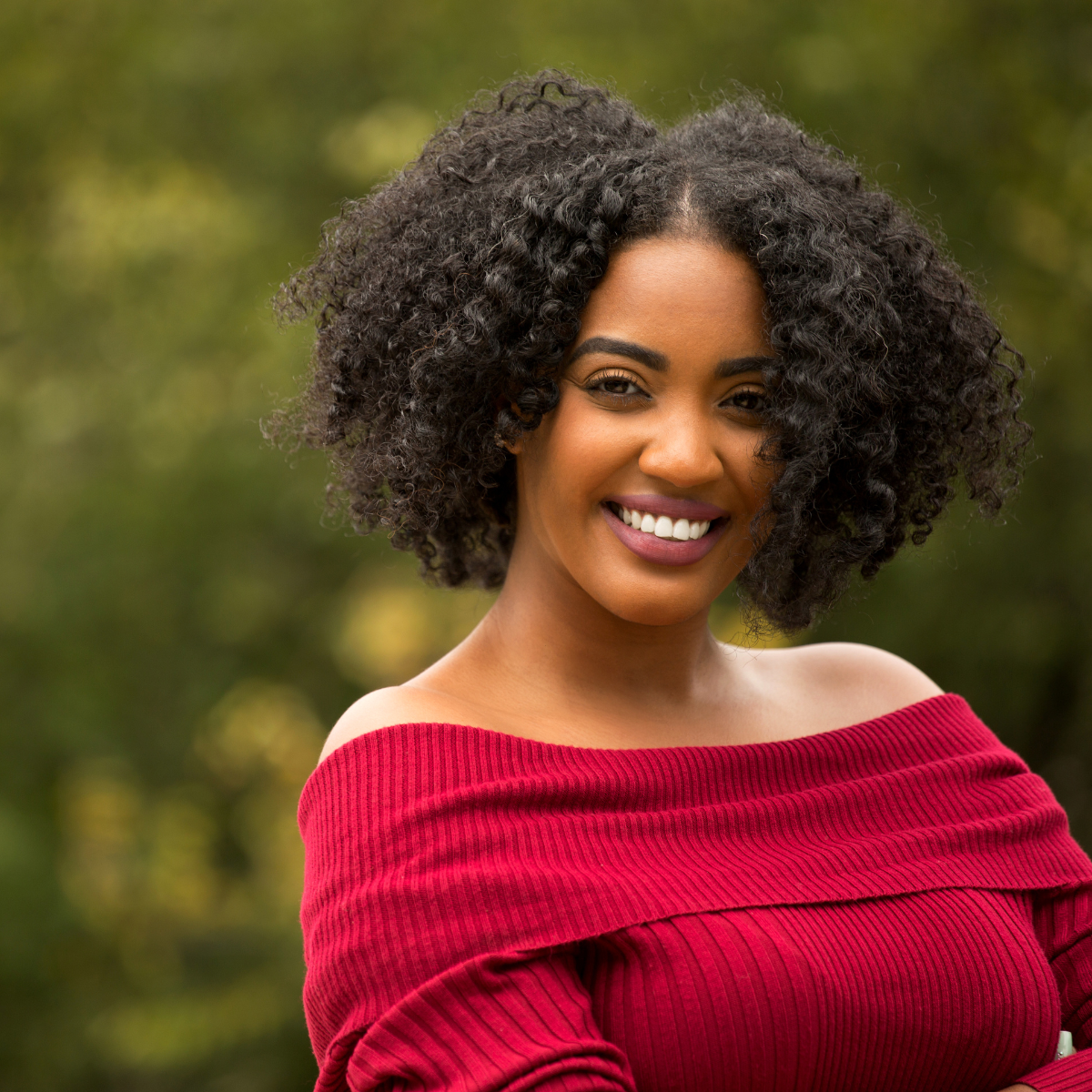 Woman with dark hair and red top smiling